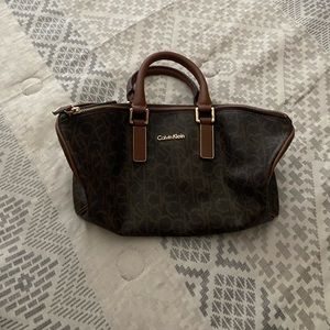 Small Brown Calvin Klein Tote Bag. Gold detailings. 1 zipper/ 2 slide pockets.
